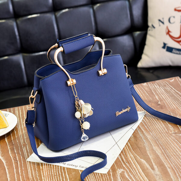 Blue handbag with gold handle and pearl charm
